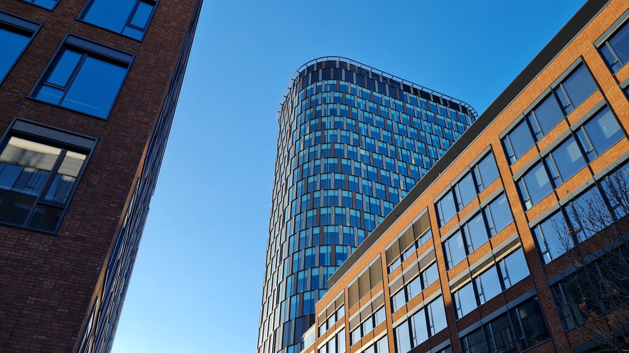 Low angle view of modern skyscrapers under a clear blue sky.
