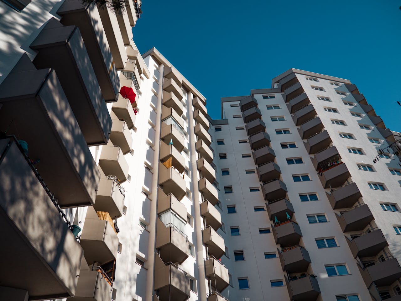 Low-angle view of modern residential apartment buildings in Berlin under clear sky.
